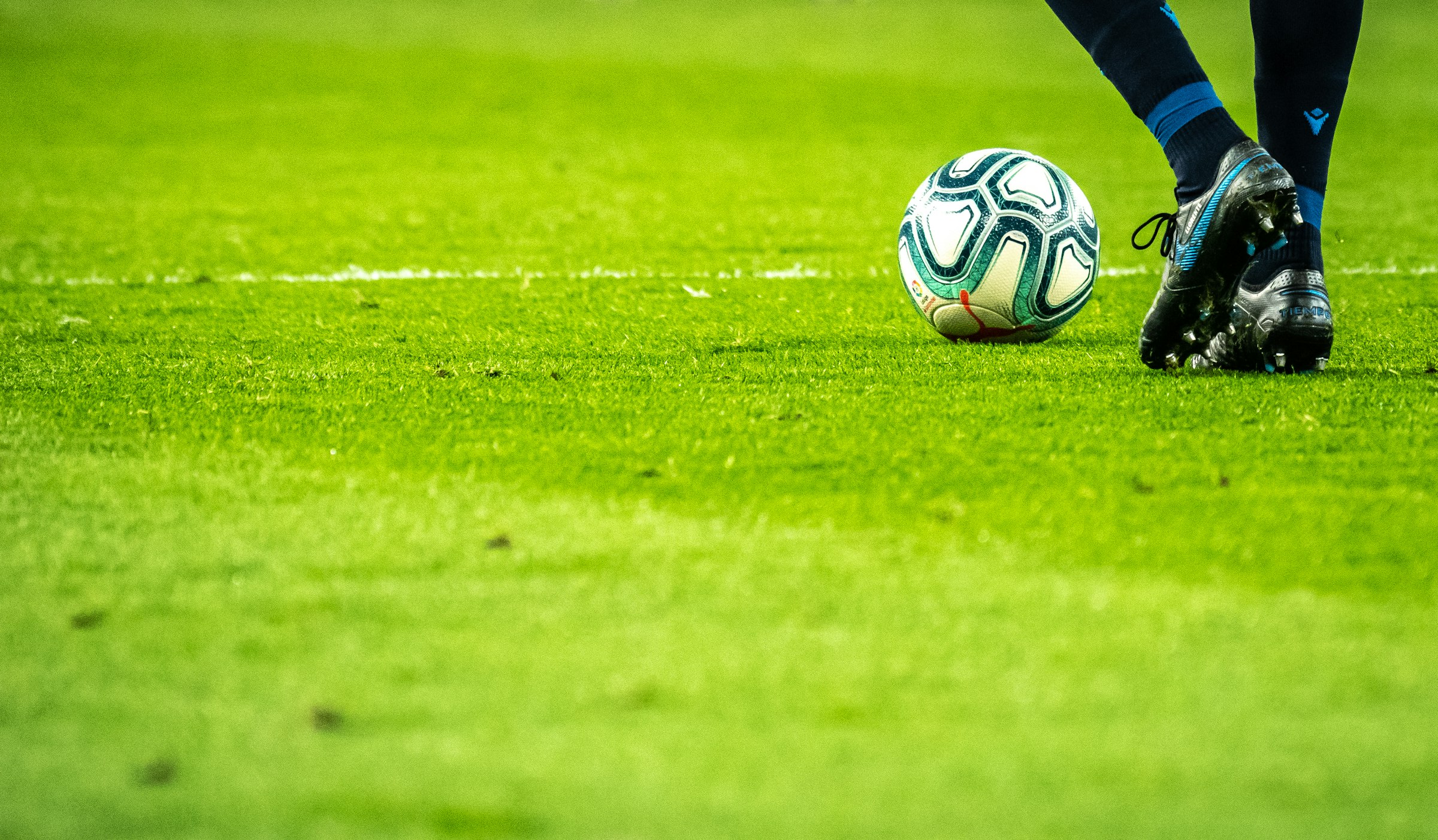 Soccer cleats and ball on the pitch